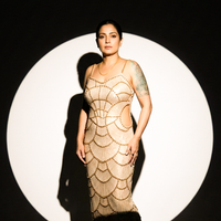 Front-facing in a bronze pearl-embellished mermaid maxi dress with side cut-outs.