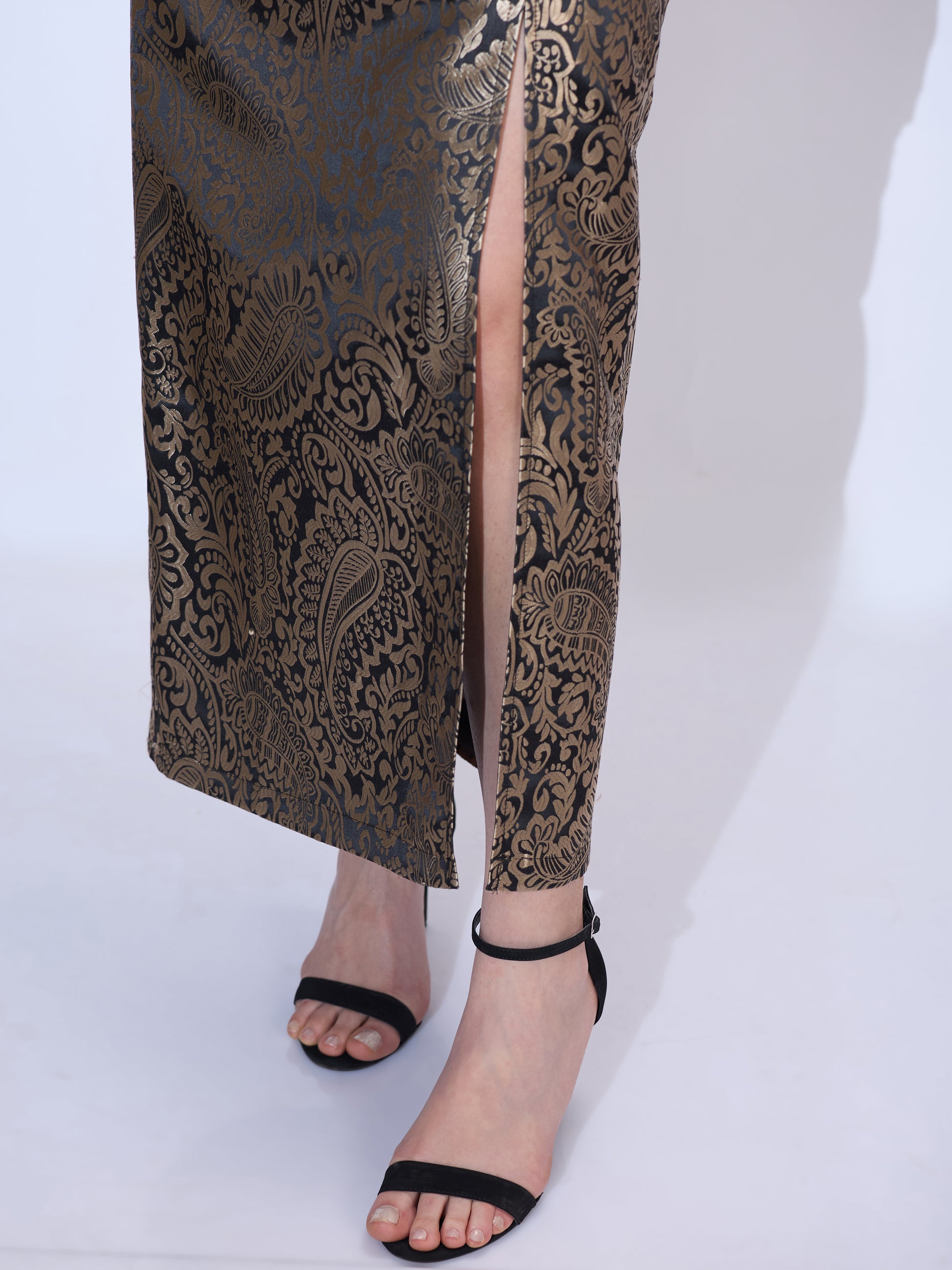 Close-up of the floor-length pencil skirt from a black and gold formal co-ord set for women in metallic brocade fabric
