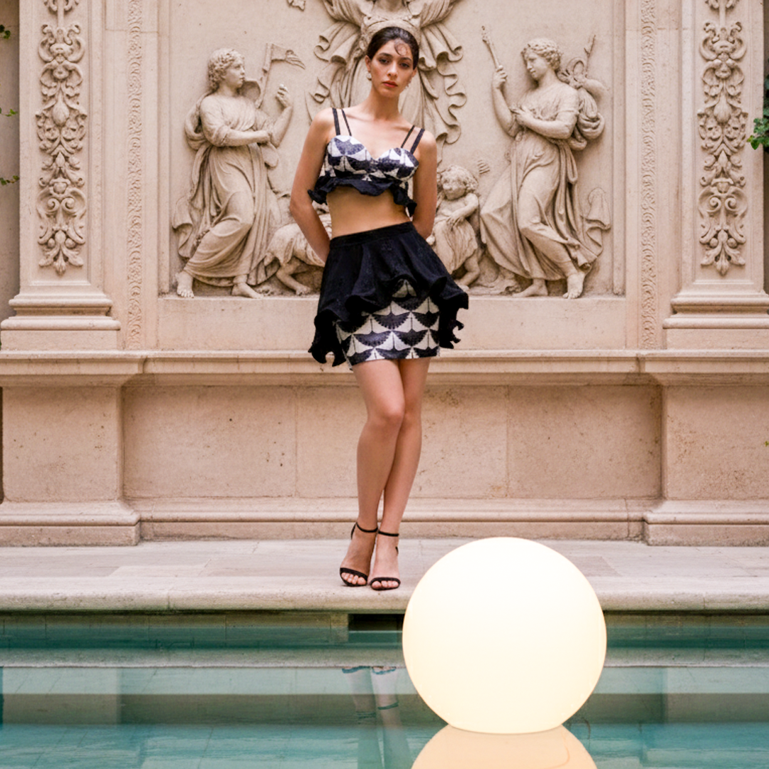 Image of Front-facing in a black and white scallop print ruffle mini skirt set with an off-shoulder top and high-waisted skirt.