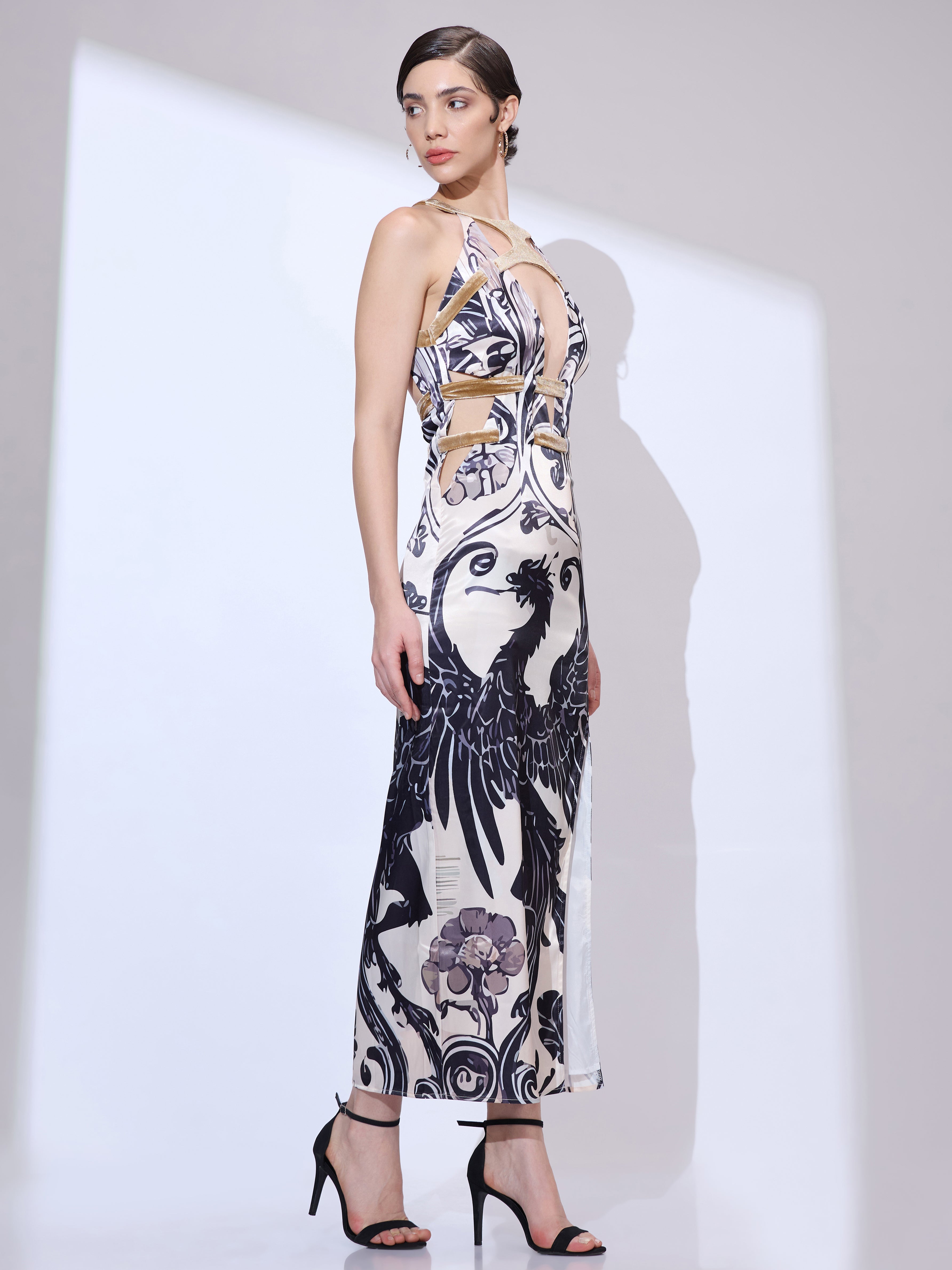Image of Standing at a side angle and looking right in a designer maxi gown with a black and white dragon print and a plunge neckline
